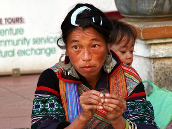 Người phụ nữ vừa bán hàng vừa địu đứa con sau lưng ở chợ vùng cao Sapa.
